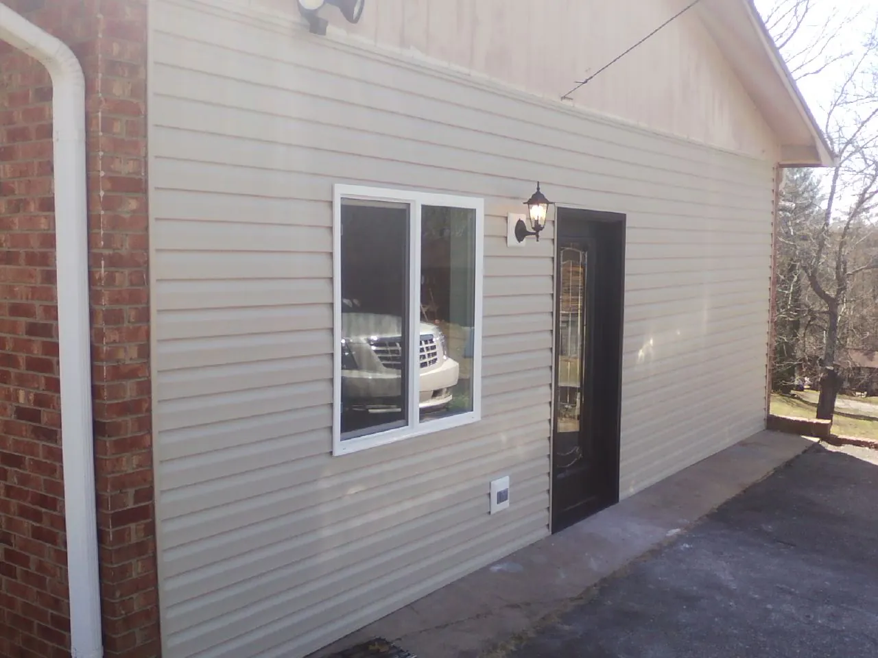 New vinyl siding and entry door on a room addition in Lake Placid