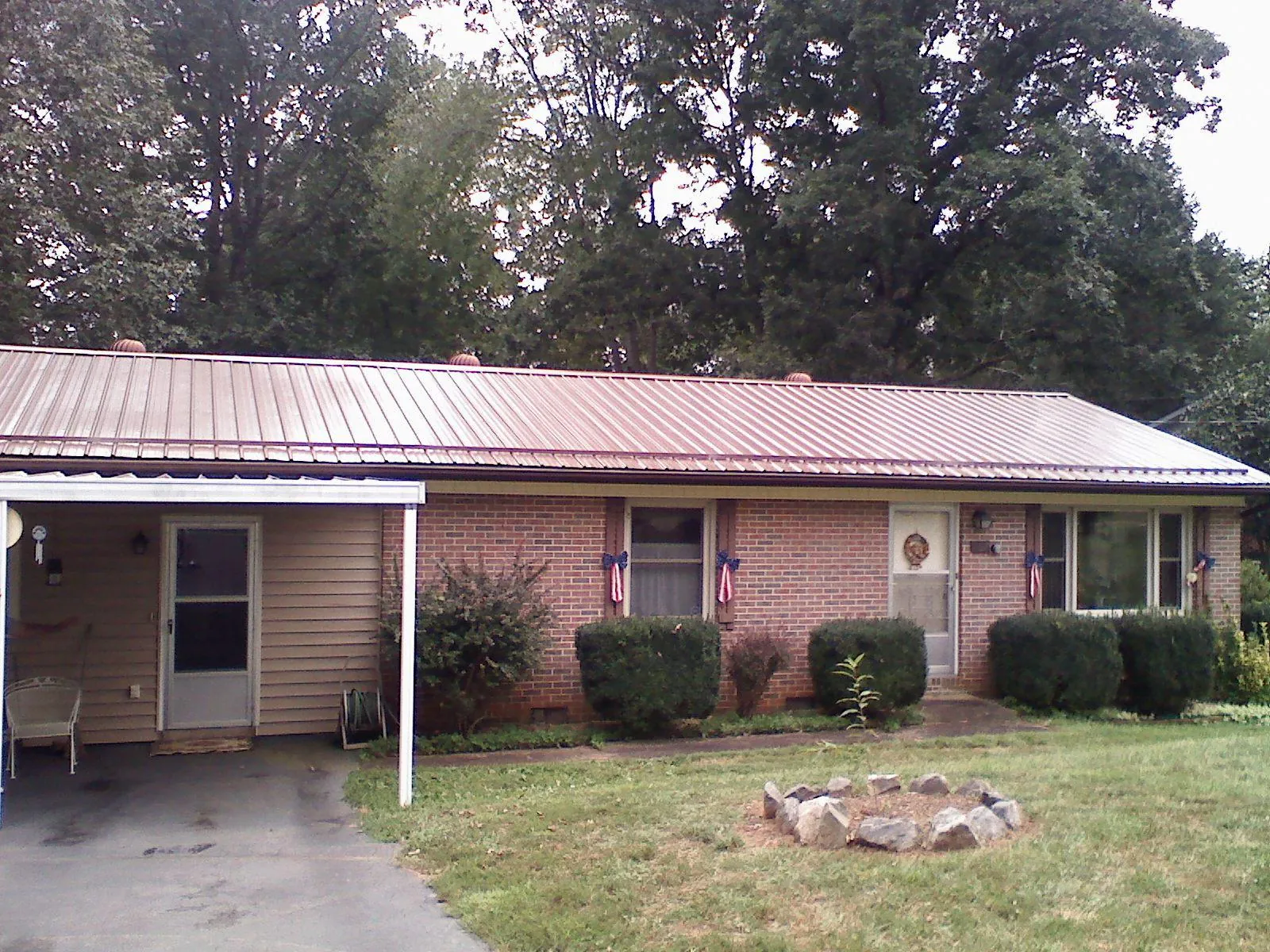 Bronze metal roof and carport on a brick ranch home — Roof Repair work by our crew in Lake Placid